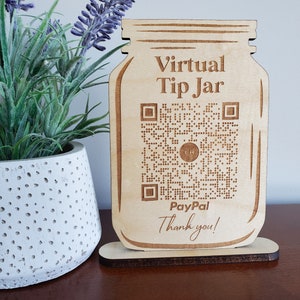 May include: A wooden cutout of a mason jar with the text "Virtual Tip Jar" and a QR code. The text "PayPal" and "Thank you!" are also included on the cutout.