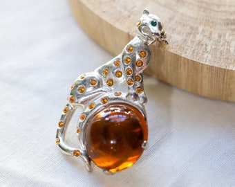 Vintage leopard brooch on a plastic ball of amber color with rhinestones.