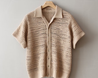 May include: A beige knitted short-sleeved cardigan with a button-up front and a collar. The cardigan has an open knit pattern.