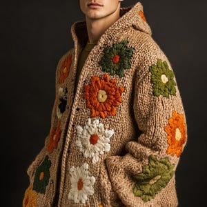 Puede incluir: Un cárdigan de punto marrón con cuello de capucha y bordado floral. El cárdigan presenta una variedad de flores de colores, incluyendo naranja, blanco, verde y amarillo.