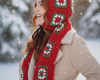 May include: A red crochet hood and scarf set with white and green square patterns. The hood is connected to a long scarf, and the set is worn in a snowy outdoor setting. The scarf is approximately 150 cm long.