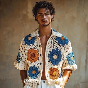 Peut inclure: Une chemise blanche en crochet avec des motifs floraux colorés. La chemise a un devant boutonné et des manches courtes.