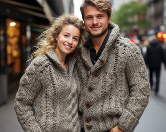 May include: A couple wearing matching gray cable knit sweaters with a collared neckline. The sweaters have a textured pattern and are buttoned up.