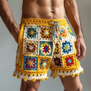 Könnte beinhalten: Bunte Häkelshorts mit geometrischem Muster in Gelb-, Rot-, Blau-, Grün- und Weißtönen. Die Shorts haben einen Kordelzugbund und einen Pomponbesatz.