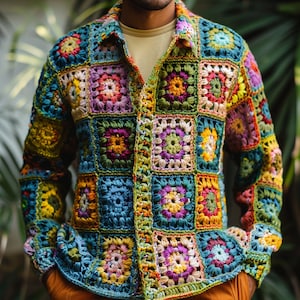 Op de afbeelding: Een kleurrijk gehaakt shirt met een knoopsluiting en lange mouwen. Het shirt is gemaakt van verschillende gekleurde vierkanten, waardoor een patchwork-ontwerp ontstaat.