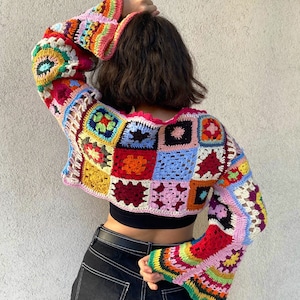 Peut inclure: Un haut en crochet coloré avec un motif patchwork et des manches bouffantes. Le haut est court et a un col carré.