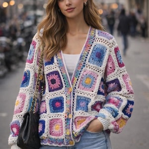 May include: A colorful, crocheted cardigan with a square pattern in shades of pink, blue, purple, and yellow. The long-sleeved sweater has a V-neck and button closure. The person is wearing blue jeans and carrying a black purse.