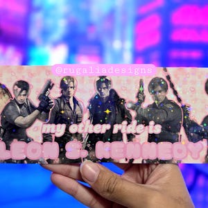 May include: A rectangular sticker featuring six images of Leon S. Kennedy in various poses, with a pink background and the text "my other ride is LEON S. KENNEDY" in pink bubble letters. The sticker has a holographic finish with small star accents.