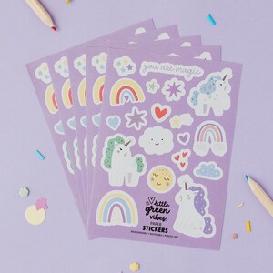 Pack of 5 Rainbows & Unicorns party bag filler sticker sheet featuring whimsical pastel illustrations of magical unicorns, colourful rainbows, floating hearts, smiling clouds, stars, and gift boxes on a lilac background, accompanied by pencils for colouring, plastic-free