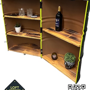 Peut inclure: Un meuble en bois fabriqué à partir d'un tonneau, avec des étagères et une porte à charnière. L'intérieur est marron, avec une bordure verte et jaune. Les étagères contiennent une bouteille de vin, des verres et des plantes décoratives. Le meuble porte le texte "LOFT DESIGN".
