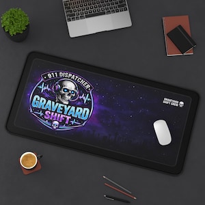 May include: Black rectangular mouse mat with a graphic featuring a skull wearing headphones, the text "911 Dispatcher Graveyard Shift," and a starry background. The mat also has the text "Graveyard Shift Crew."