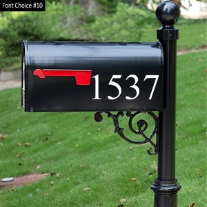 May include: Black mailbox with a white number 1537 on the front. The mailbox has a red flag.