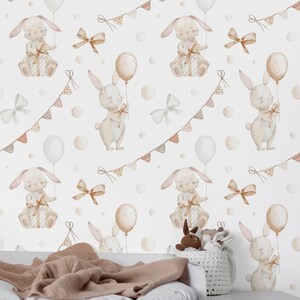 May include: A repeating pattern of watercolor bunnies holding balloons and gifts, with bows and bunting on a white background. The bunnies are in a soft beige color, with pink accents. The balloons are white and beige.