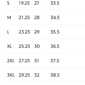 May include: A sizing chart table with the heading Sizing, listing sizes from S to 5XL. Columns include Width (in), Length (in), and Sleeve center back (in). Measurements are provided in inches for each size, with a note at the bottom stating * in = Inch.