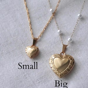 May include: Two gold-colored heart-shaped locket necklaces. One is smaller, the other is larger. The larger locket has a pearl chain. The word "Small" is below the smaller locket, and "Big" is below the larger one.