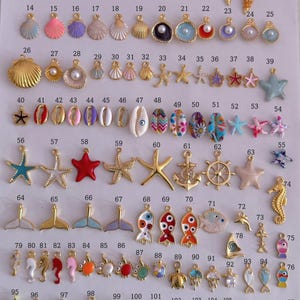 Puede incluir: Una colecci&oacute;n de abalorios dorados y coloridos en varias formas, incluyendo conchas marinas, estrellas de mar y criaturas marinas. Estos abalorios son adecuados para la fabricaci&oacute;n de joyas y proyectos de artesan&iacute;a. Los abalorios est&aacute;n dispuestos sobre una superficie blanca.