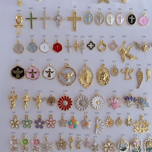 Puede incluir: Una colecci&oacute;n de colgantes y abalorios dorados, que incluyen cruces, dise&ntilde;os florales y s&iacute;mbolos religiosos. Los colgantes var&iacute;an en tama&ntilde;o y detalle, algunos con detalles de esmalte y piedras preciosas.