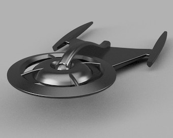 Puede incluir: Un modelo de nave espacial de color negro, de aspecto futurista, con una base circular y una parte superior triangular puntiaguda. El modelo tiene un acabado metálico elegante.
