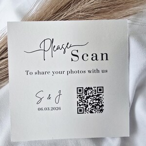 May include: Square, off-white card with the words "Please Scan" in elegant script. Below, it reads "To share your photos with us." Includes a QR code and the initials "S & J" with the date 06.03.2026.