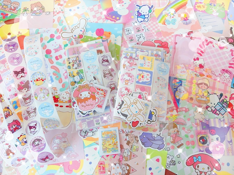 May include: A colorful assortment of stickers and stationery featuring various cartoon characters. The image showcases a variety of designs, including circular stickers, rectangular sticker sheets, and decorative paper, all in a pastel color palette.