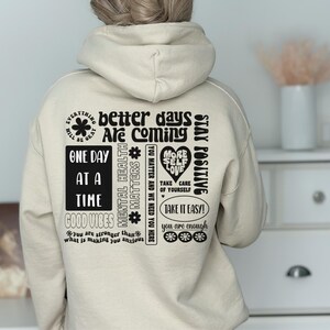 Pode incluir: Um moletom com capuz bege com texto preto que diz "Tudo vai ficar bem", "dias melhores est&atilde;o chegando", "um dia de cada vez", "boas vibra&ccedil;&otilde;es", "sa&uacute;de mental importa", "voc&ecirc; importa e precisamos de voc&ecirc; aqui", "mais amor pr&oacute;prio", "cuide-se", "mantenha-se positivo", "v&aacute; com calma", "voc&ecirc; &eacute; suficiente".