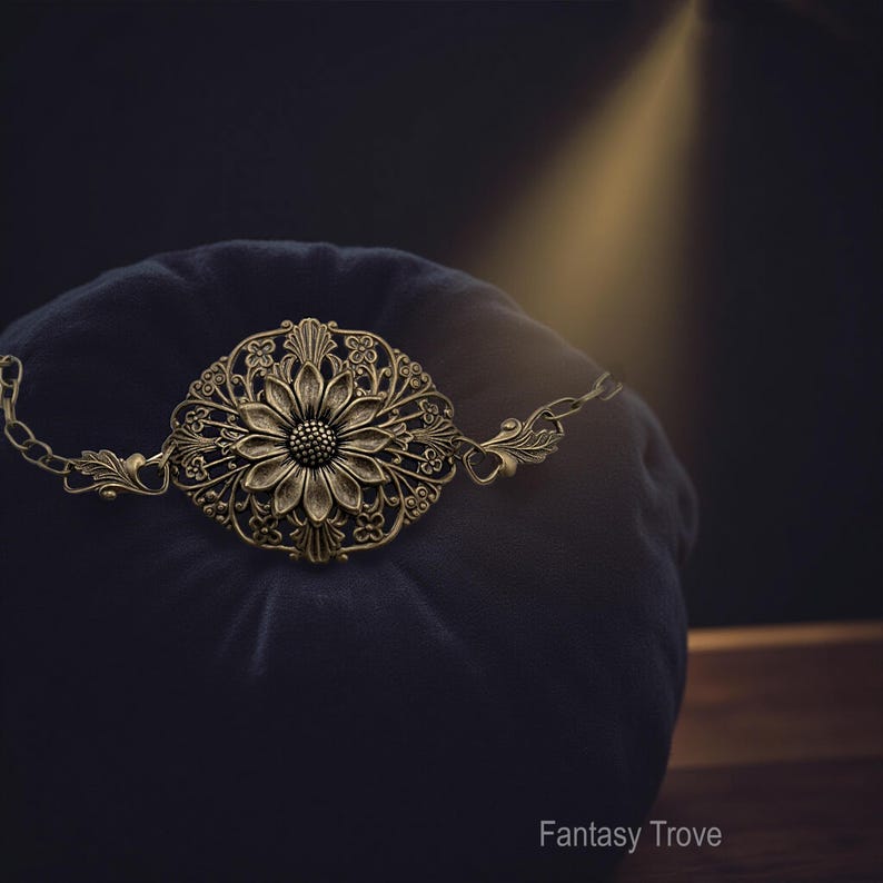 Vintage brass sunflower bracelet with leaf detail displayed on dark velvet pillow.
