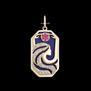 Puede incluir: Colgante de oro con un diseño azul y blanco que presenta el perfil de una mujer. El colgante está acentuado con un grupo de piedras preciosas rosas.