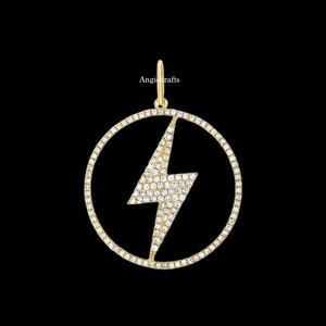 Peut inclure: Un pendentif en or avec un motif d'éclair et un cercle de diamants sertis pavé autour du bord.