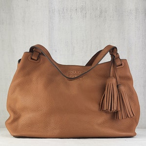 Bolso tote de cuero con cremallera central y borlas Thea de Tory Burch y logo