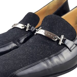 May include: Black leather and suede loafers with a silver chain and "CELINE" nameplate detail.