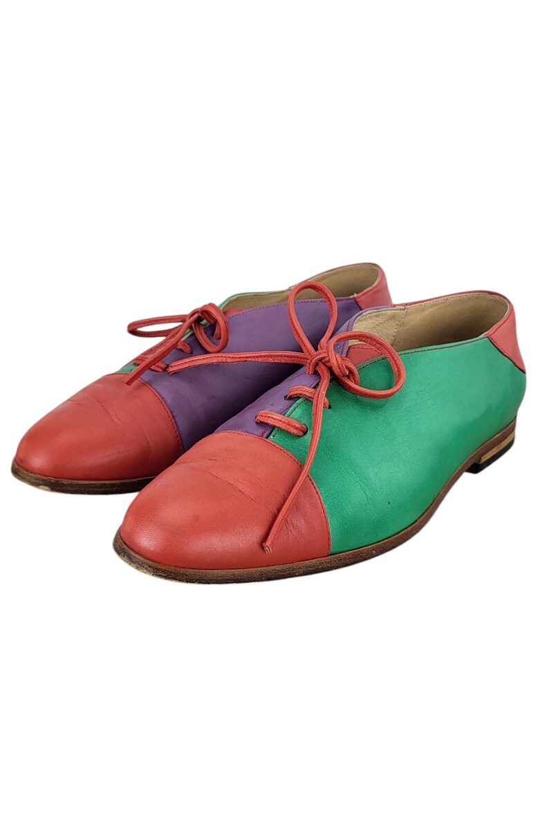 以下が含まれることがあります： 赤、緑、紫の革製のレースアップシューズのペアです。