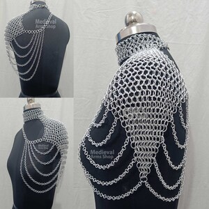 May include: Silver chainmail shoulder armor with a decorative chainmail collar. The armor is made of interlocking metal rings and has a flowing, cascading design. The text "Medieval Arms Shop" is visible on the armor.