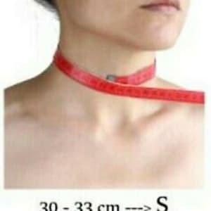 May include: A red measuring tape is wrapped around a person's neck to show how to measure for a choker necklace. The image includes a chart with choker sizes in centimeters and corresponding sizes: S, M, and L.