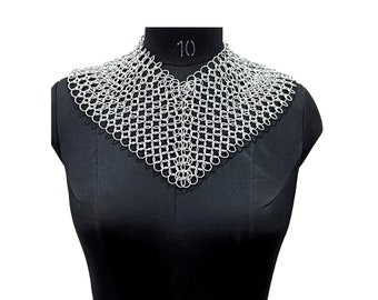 May include: A silver chainmail collar necklace on a black mannequin. The collar is a triangular shape with a rounded bottom edge.