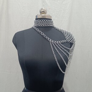 May include: Silver chainmail choker necklace and shoulder piece. The choker is a simple chainmail design, while the shoulder piece is a more elaborate design with multiple chains.