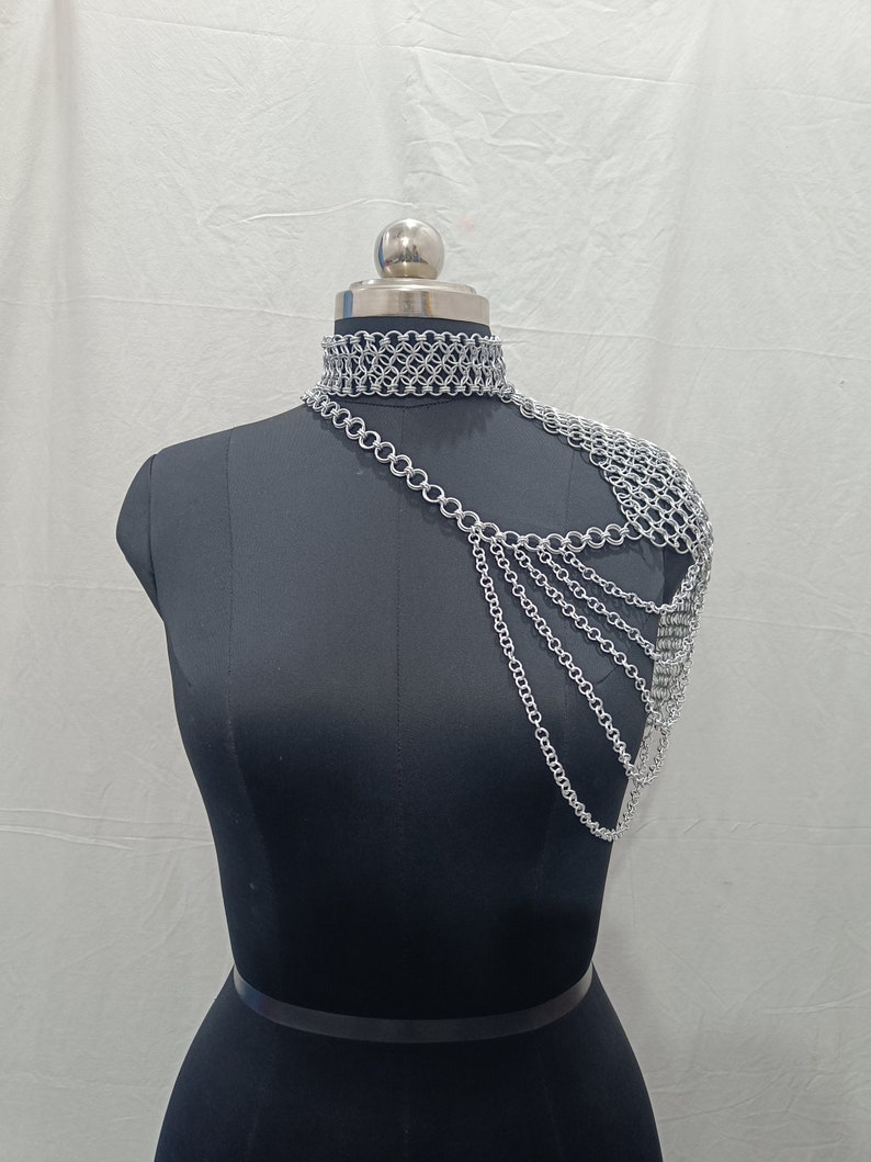 May include: Silver chainmail choker necklace and shoulder piece. The choker is a simple chainmail design, while the shoulder piece is a more elaborate design with multiple chains.