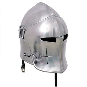 May include: A silver helmet with a visor and a cross on the front. The helmet has a pointed chin guard and a strap that goes under the chin.