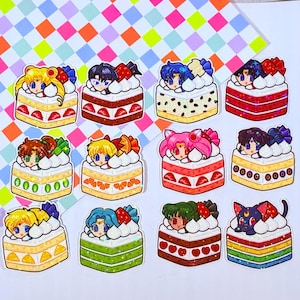 Op de afbeelding: Twaalf kleurrijke taart stickers met personages uit de anime Sailor Moon. Elke sticker heeft een ander Sailor Scout-personage met een uniek taartontwerp. De stickers zijn perfect om een ​​toets van whimsy toe te voegen aan laptops, waterflessen of planners.