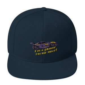 Puede incluir: Una gorra de béisbol azul marino con un diseño bordado en amarillo y morado de un coche de carreras y el texto "I'm a gamer Forza-ever!"
