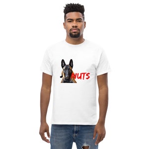 May include: A white t-shirt with a graphic of a brown and black Belgian Malinois dog with the word "NUTS" in red text.