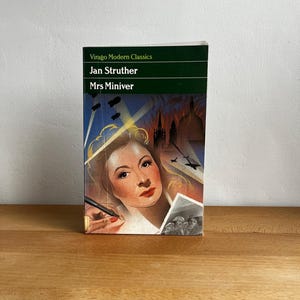 May include: A copy of "Mrs Miniver" by Jan Struther, from the Virago Modern Classics collection. The cover art depicts a woman writing, set against a background of buildings and aircraft, in shades of blue and yellow.