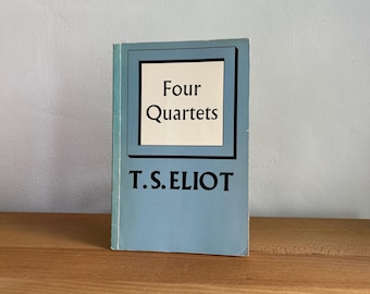 May include: A blue book with the title "Four Quartets" by T.S. Eliot.