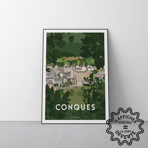 May include: A framed art print featuring a stylized illustration of the town of Conques, France, in shades of green, white, and gray. The print includes the town's name in white block letters and is surrounded by leafy foliage.