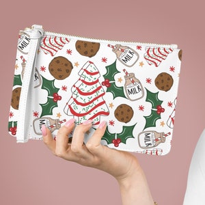 May include: White zippered pouch with a Christmas-themed print featuring candy canes, milk bottles, cookies, and holly leaves. The print is on a white background.