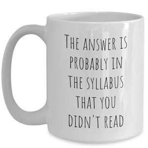 Puede incluir: Taza de caf&eacute; de cer&aacute;mica blanca con texto negro que dice "La respuesta probablemente est&aacute; en el temario que no le&iacute;ste".