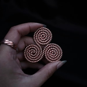 May include: Three copper-colored, spiral-shaped, round ornaments.