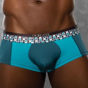 May include: Teal and blue boxer shorts with a black and white geometric pattern waistband. The waistband has the text "DOREANSE" printed on it.