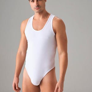 May include: A white sleeveless bodysuit with a scoop neck.