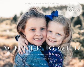 May include: Two young girls with blonde hair are smiling and hugging. The girl in the front is wearing a blue denim jacket with a floral pattern. The girl in the back is wearing a blue denim jacket with a white and blue floral pattern. The text "WHITE GOLD" is written in white letters on a blurred background.