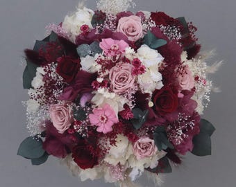 Enchanting bridal bouquet of dried flowers in berry tones, cream and white with stabilized roses